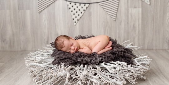 newborn baby boy on gender neutral gray and white