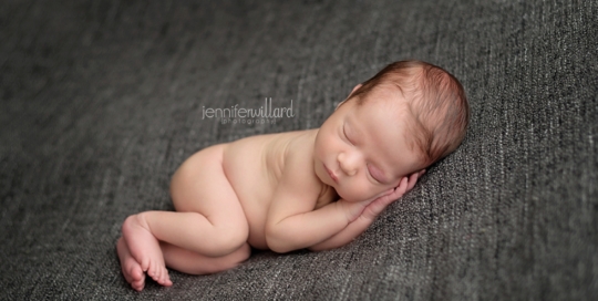 newborn baby boy on grey blanket