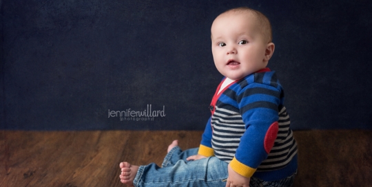 baby boy in studio on wood with blue backdrop