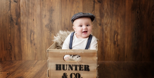 baby boy in crate with poor boy hat