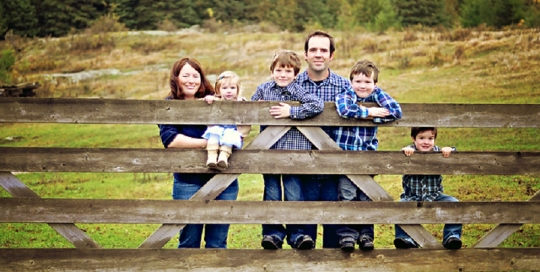 family with young kids on farm rain fence