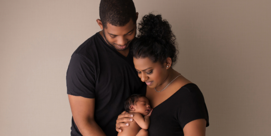 African American newborn girl with parents in black shirt