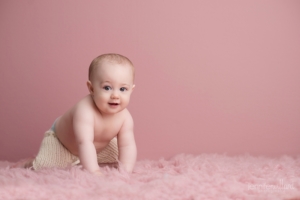 baby-milestone-6-months-old-crawling-pink-rug-pink-background