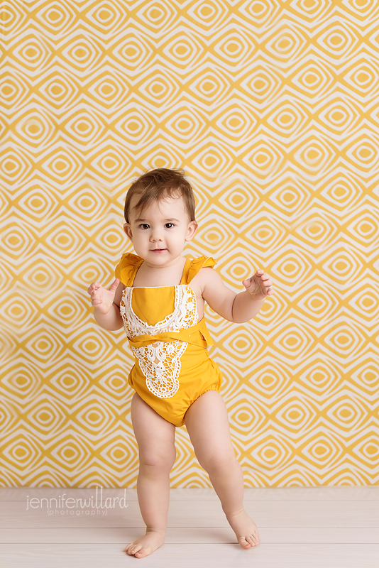 yellow-romper-yellow-backdrop-wood-white-floor-baby-girl-milestone-portrait-kingston-ontario-photography-studio