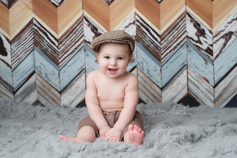 baby-mini-session-portrait-boy-poor-boy-hat-grey-rug-chevron-wood-backdrop-ygk