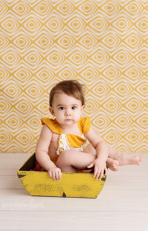 vintage-bucket-baby-girl-sitting-yellow-romper-yellow-background-kingston-photographer