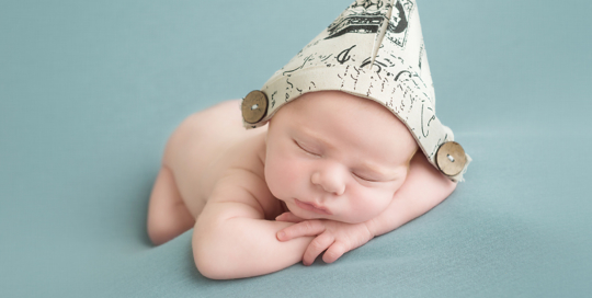 baby boy on light blue blanket with fabric sailor pirate hat in kingston photography studio