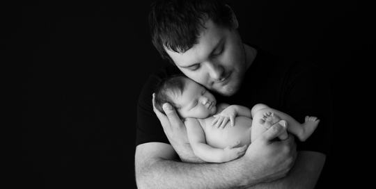 baby girl with dad on black background in black and white at kingston photography studio