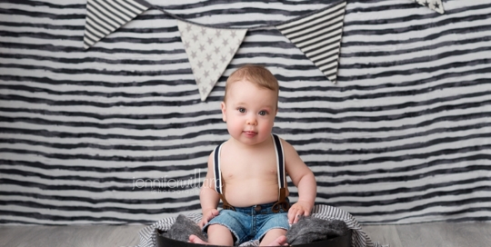 Baby Boy 6 Month Milestone Portraits black stripe backdrop black and white pennant banner with suspenders in Kingston Ontario Photography Studio_0003