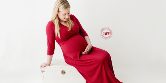 Pregnant woman in red dress in kingston ontario portrait studio