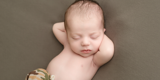 baby boy in army camo pants on green grey blanket in kingston photography studio