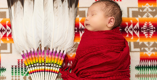 baby boy in red wrap on native blanket with native fan in kingston photography studio