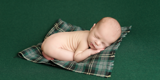 baby boy on green blanket with green plaid wrap at kingston ontario baby studio