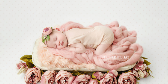 baby girl in pink romper with flowers in kingston ontario newborn studio