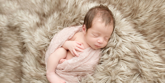 baby girl in pink wrap with brown fur in kingston ontario photography studio