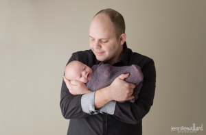 newborn baby boy grey romper father beige wall Jennifer Willard Photography Kingston