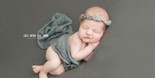 newborn baby girl on grey blanket with grey headband and mohair wrap in kingston ontario baby photography studio