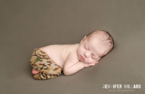 newborn baby of military parents with camo army pants on in kingston ontario baby photography studio