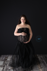 pregnant mom in black lace and tulle dress on grey background by Kingston Maternity Photographer