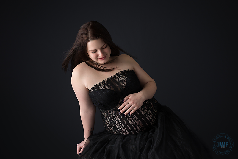 Pregnant Mother in black lace dress with black tulle skirt in portrait studio by Jennifer Willard Photography