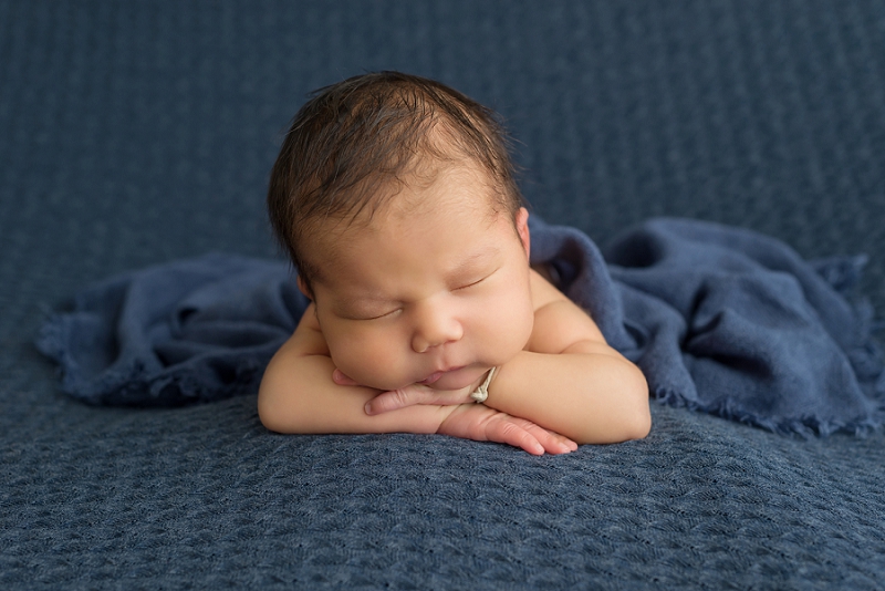 First Nations newborn baby boy head on hands on blue blanket with heirloom bracelet by Belleville Newborn Photographer