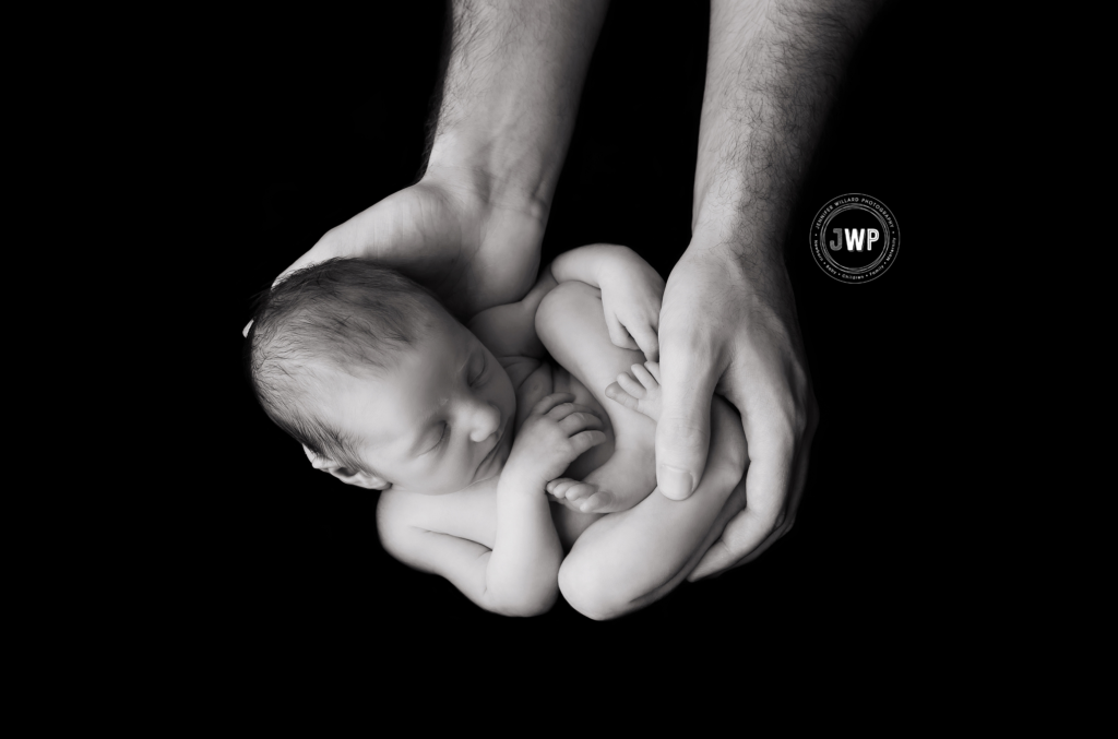 black and white newborn girl in daddy's hands