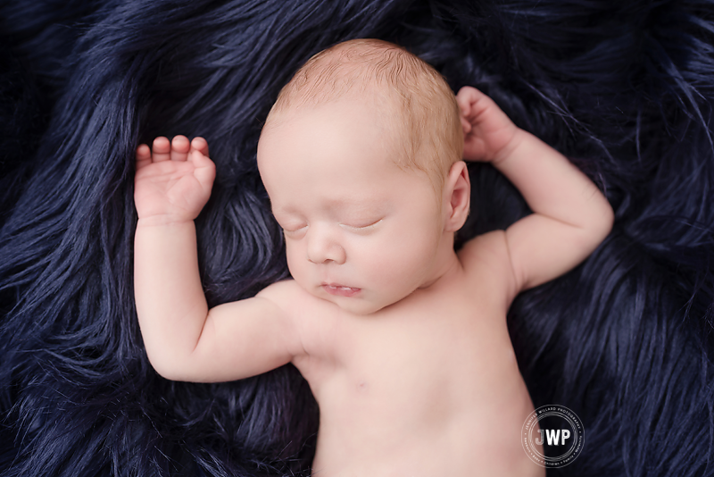 newborn-baby-boy-blue-flokati-lying-on-back-Kingston-Photographer