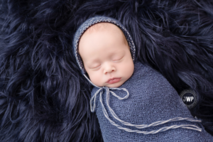 newborn-baby-boy-in-blue-wrap-with-bonnet-up-close-by-Kingston-Newborn-Photographer