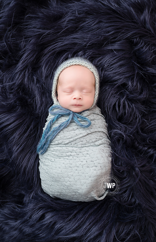 newborn-baby-boy-in-sage-wrap-with-knit-bonnet-by-Kingston-Photographer