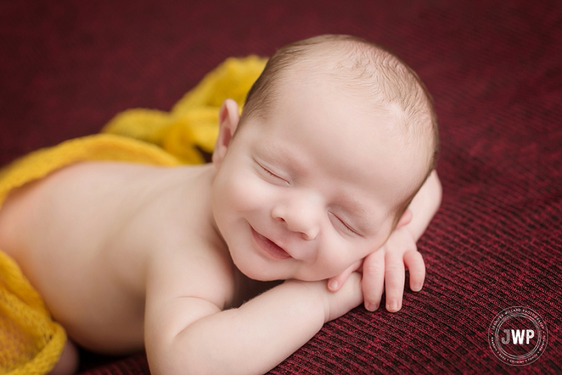 newborn posed portrait baby smiling burgundy blanket Kingston Newborn Photographer