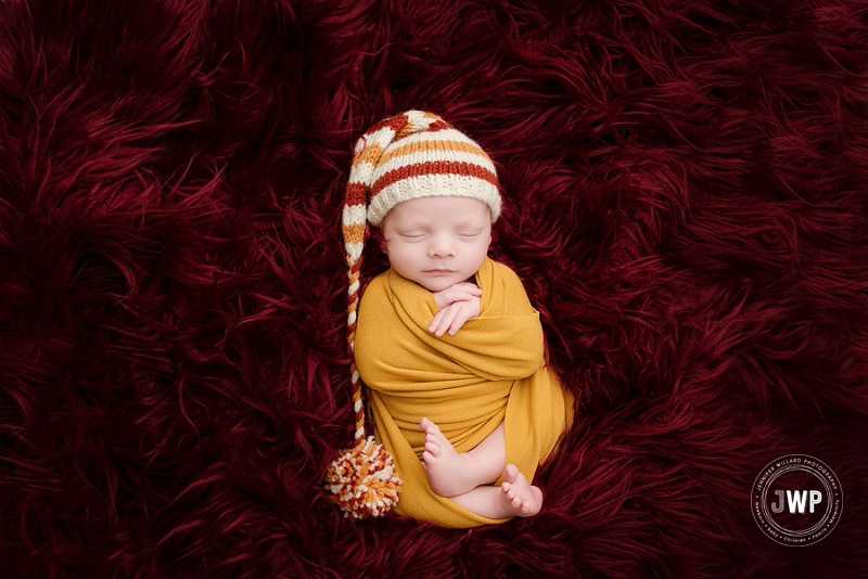 newborn posed portrait burgundy fur mustard wrap yellow striped hat Kingston Newborn Photographer