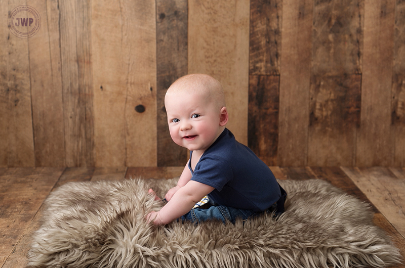 posed baby portrait 6 months old wood backdrop Kingston Children Photographer