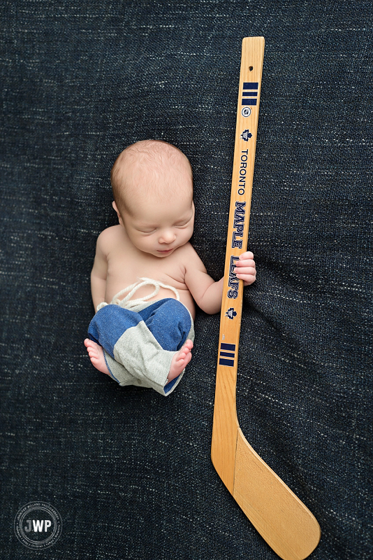 posed newborn picture blue blanket hockey stick Kingston Newborn Photographer