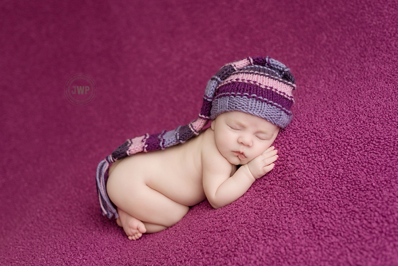 posed newborn picture purple blanket stripped hat Kingston Newborn Photographer