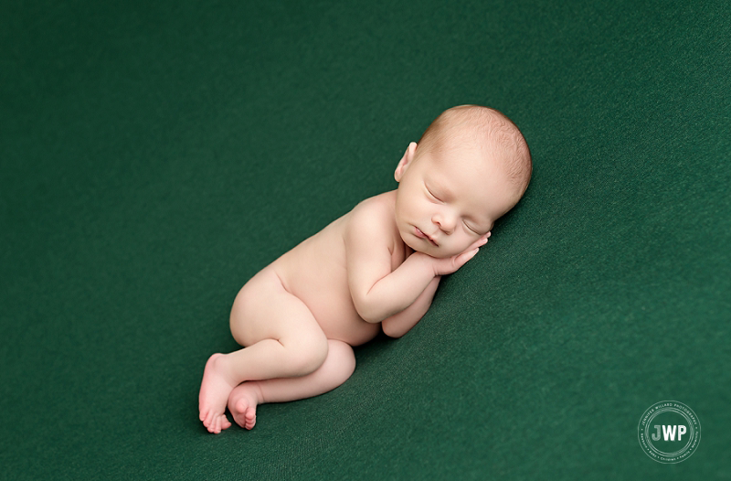 side lying posed newborn picture green blanket Kingston Newborn Photographer