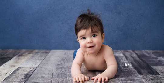 posed baby milestone portrait blue backdrop grey floor Kingston Baby Photographer