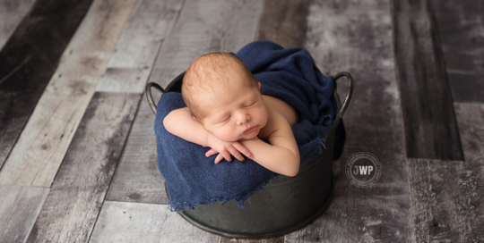 baby posed portrait grey wood floor blue wrap bucket Kingston Newborn Photographer