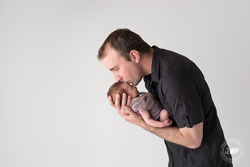 father kissing newborn daughter Kingston infant photographer