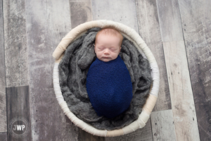 newborn boy blue wrap grey wood floor Belleville Newborn Photographer