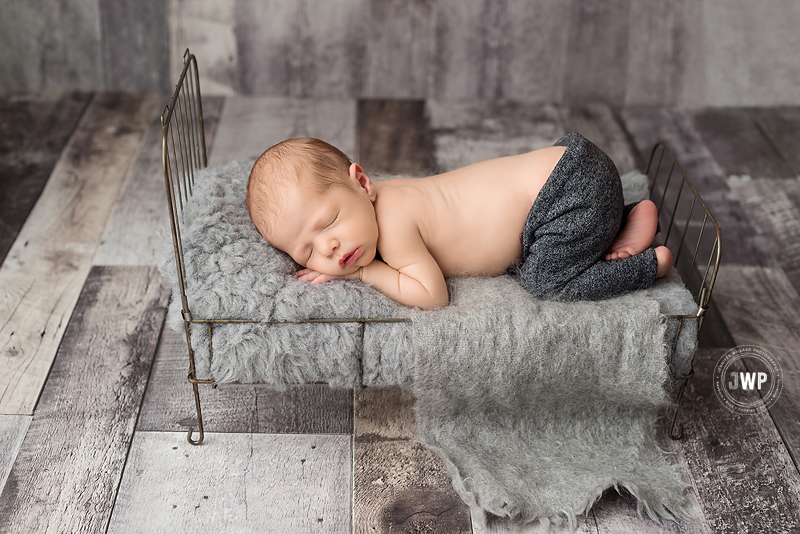 newborn boy grey pants wire bed