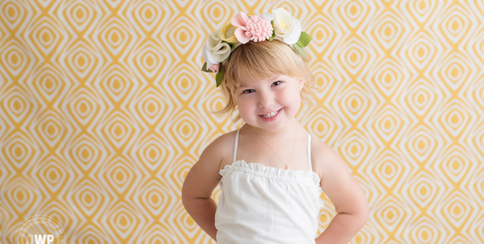 toddler girl yellow backdrop flower crown white dress Kingston children photographer