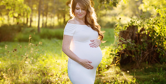 pregnant woman white dress red hair golden hour field Kingston maternity photographer