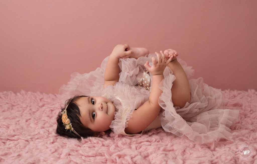 6 month old girl laying down blush pink ruffle dress Kingston baby photographer
