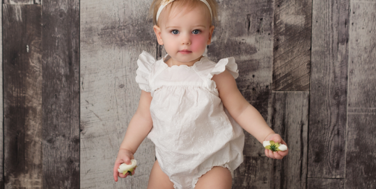 baby girl white romper grey backdrop flowers Kingston baby photographer