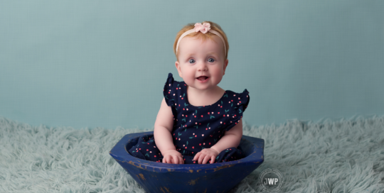 6 month old girl in blue dress with blue backdrop Kingston photographer