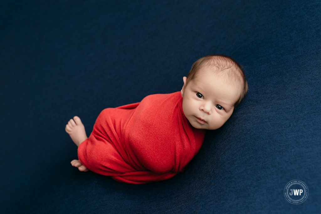 baby boy red wrap blue backdrop Kingston ontario newborn photographer