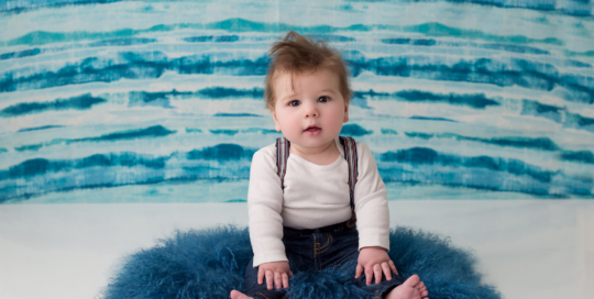 baby boy suspenders blue watercolour backdrop blue fur rug kingston baby photographer 6 months old