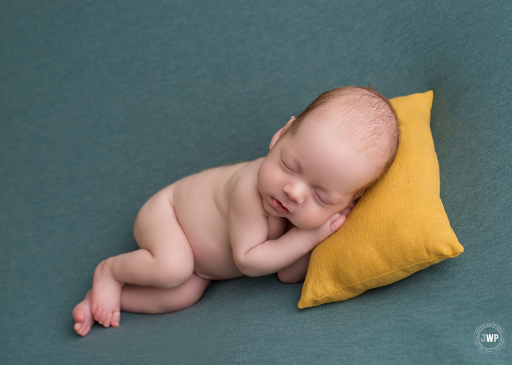 baby boy sleeping on side yellow pillow blue blanket Brockville newborn photographer