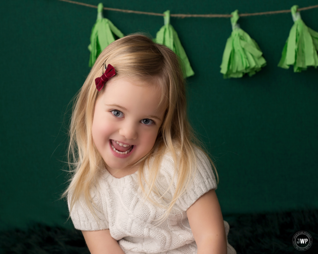 girl smiling emerald backdrop green tassel garland Kingston family photographer