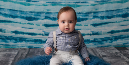 baby boy sitting blue backdrop grey wood floor Kingston first birthday photographer